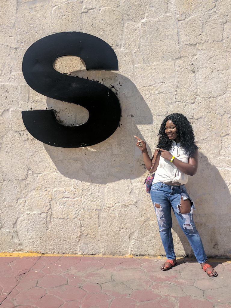a lady pointing to the letter s