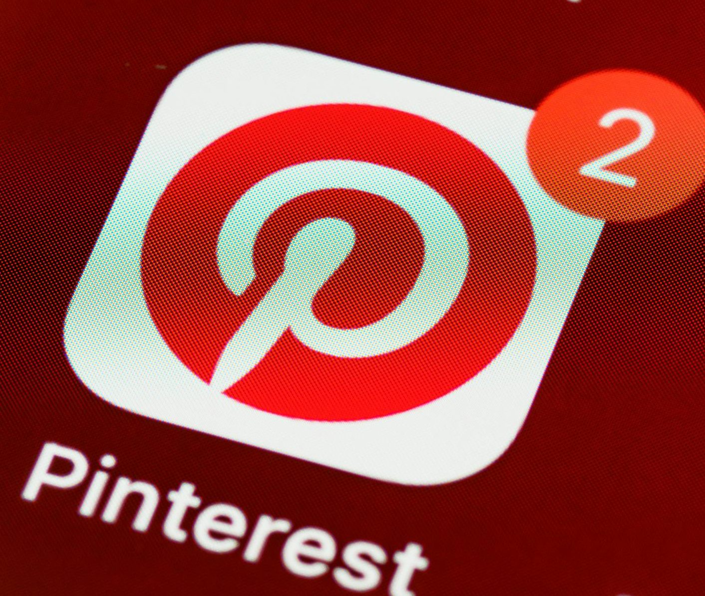Close-up of Pinterest app icon and notifications on a smartphone screen, detailed and vibrant technologically themed image.