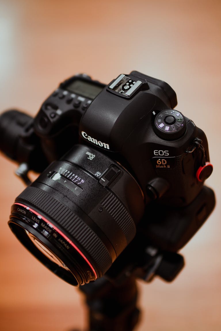 Close-up of a Canon DSLR camera with a lens mounted on a tripod.